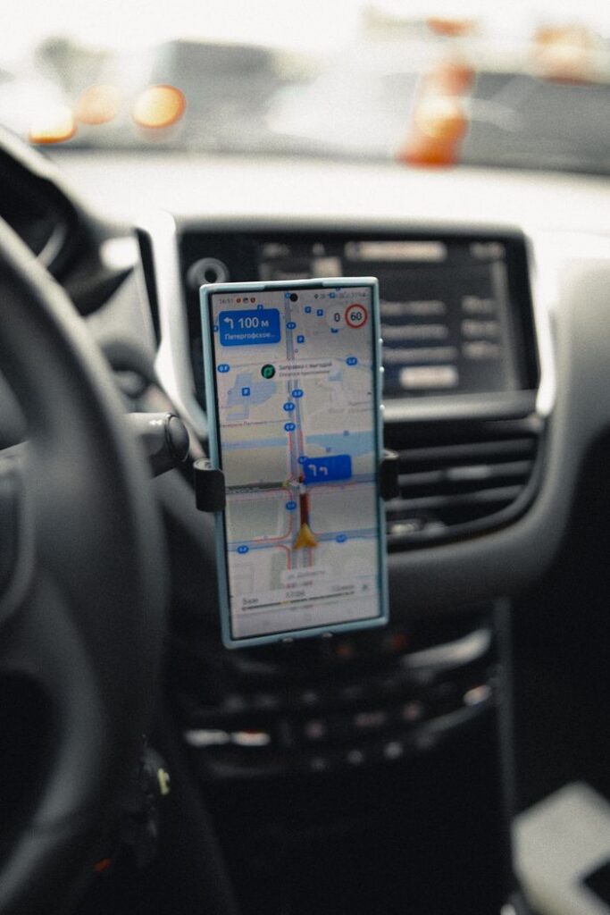 A close-up of a smartphone displaying GPS navigation in a modern car interior.